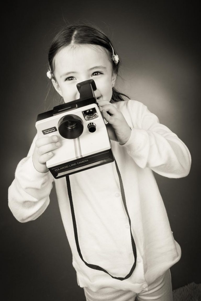 Kind mit Polaroidkamera